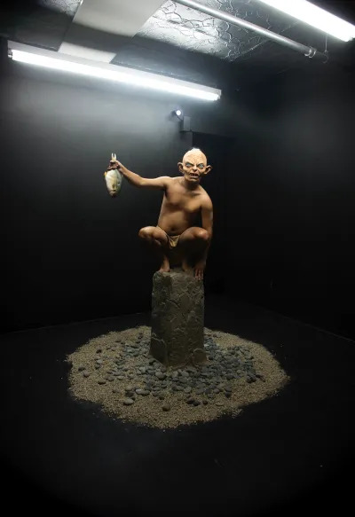 A sculpture of Gollum holding a fish.