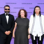 From left, Angelo Baque, Sally Talent, and Sable Elyse Smith in front of a purple backdrop reading Queens Museum.