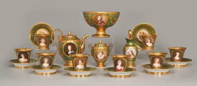 A group of teacups and bowls, as well as a kettle, with painted images of white women