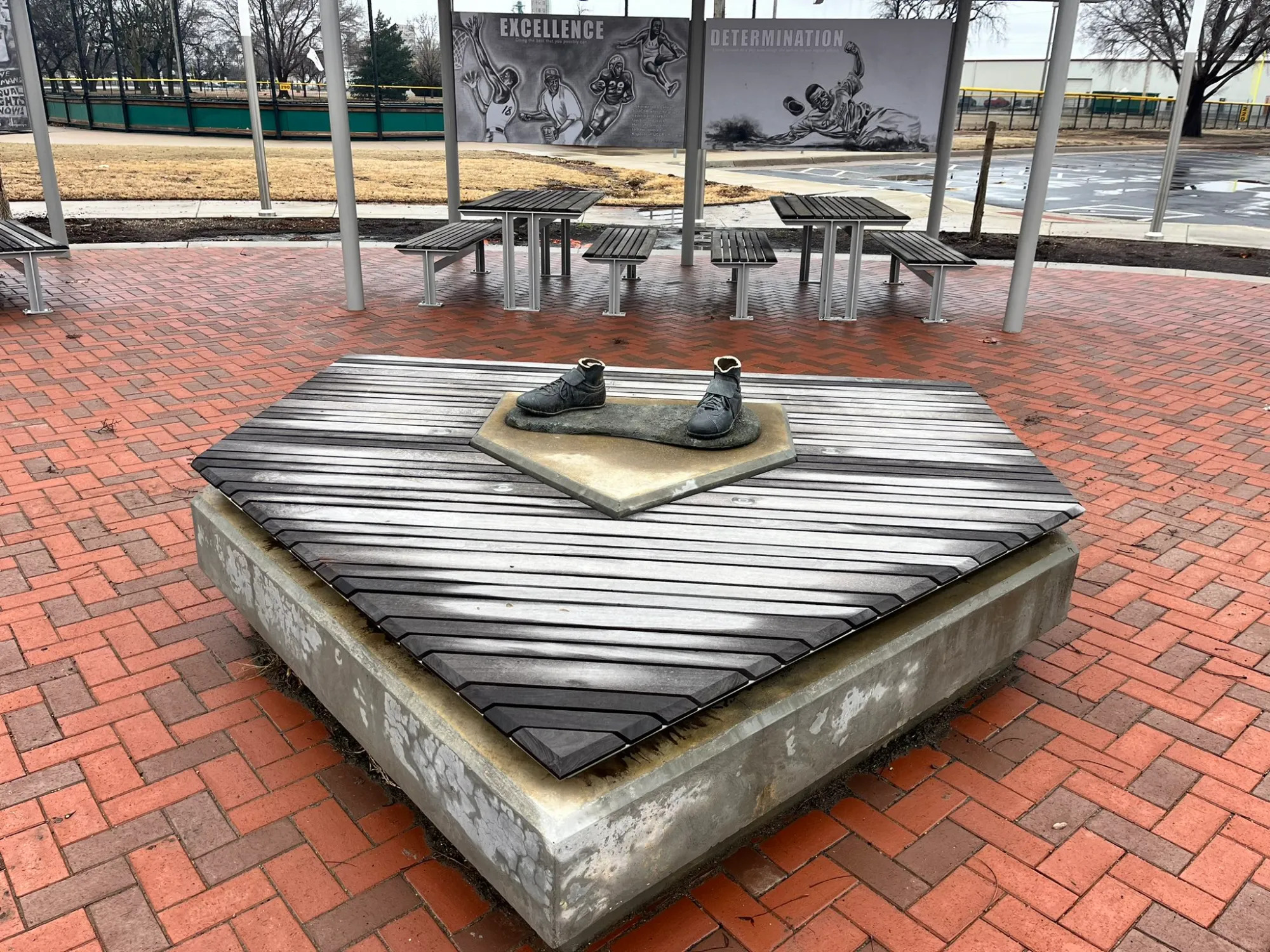 A concrete and wooden platform where a bronze statue of Jackie Robinson stood in a public park in Wichita, Kansas. Thieves cut the statue at its ankles, leaving only the player