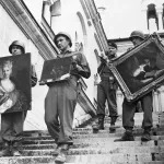 (Original Caption) Nazi Art Loot in American Hands. Fussen, Germany: While a lieutenant checks his list (background), 7th Army soldiers carry three valuable paintings down the steps of Neuschwanstein Castle at Fussen, Germany, where they were a part of the collection looted by the Nazis from conquered countries. The pictures are, left to right: Cat and Mirror, Charbin, 1749; Painting by Brouver, belonging to the Weissman Collection; and a portrait of a lady marked Rothchild Collection 16th Century. Hermann Goering presumably intended to use this priceless collection in forming his art gallery at Linz, to be named after him and presented to the Reich on his 60th birthday.