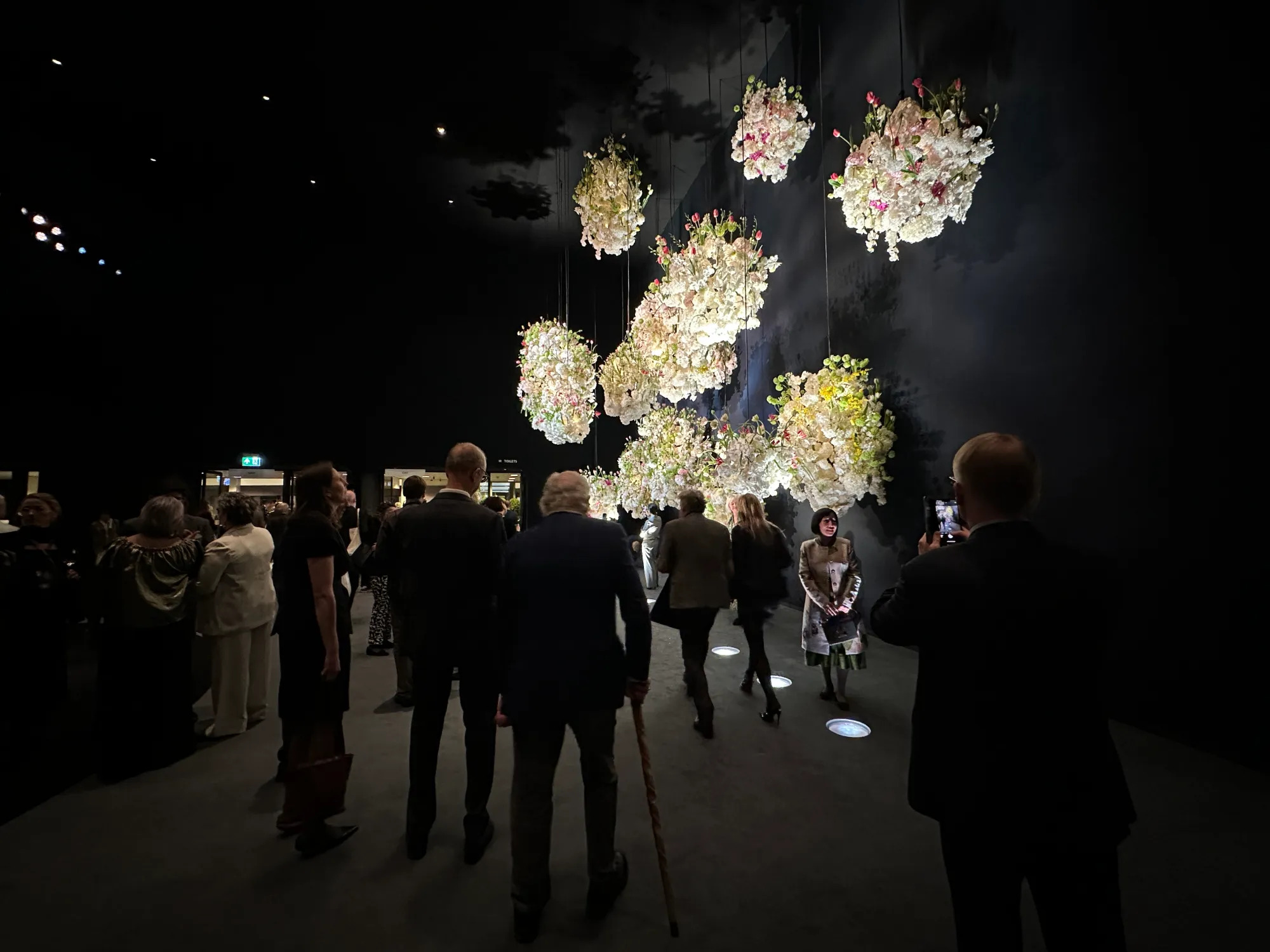 People admire the flowers that hang at the entrance of The European Fine Art Fair (TEFAF).