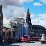 Firefighters work to extinguish the historic Boersen stock exchange building (C) in central Copenhagen, Denmark on April 16, 2024. The building, one of the oldest in the Danish capital, was undergoing renovation work when in the morning it caught fire, whose cause was yet unknown. The building was erected in the 1620s as a commercial building by King Christian IV and is located next to the Danish parliament. (Photo by Mads Claus Rasmussen / Ritzau Scanpix / AFP) / Denmark OUT (Photo by MADS CLAUS RASMUSSEN/Ritzau Scanpix/AFP via Getty Images)