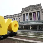 A museum facade with a giant sculpture reading 