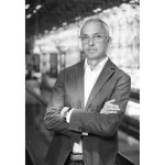 Black and white photo of Photofairs New York founder Scott Gray. He is wearing a suit jacket, glasses, a white dress shirt, and has his arms crossed.