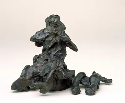 A bronze sculpture that is a twisted forms of abstract shapes that resemble a person. 