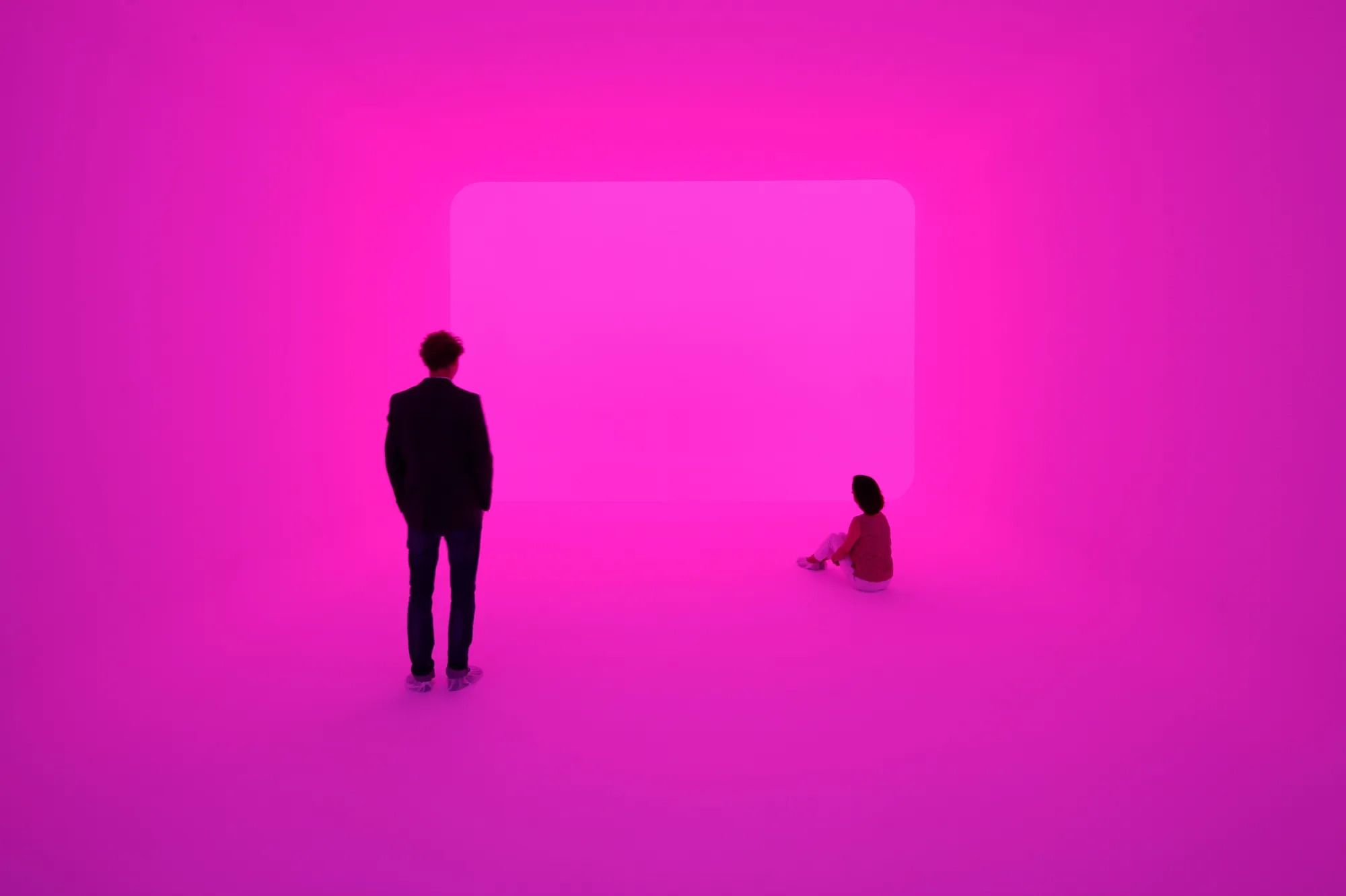 A man and a girl in a glowing pink room.