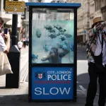 A police box painted with a fish mural.