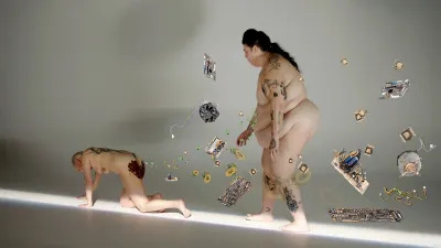 A nude woman walking behind a nude person whose butt is smeared with fecal matter. The crawling person appears to emit hardware, wiring, and computer keys from his anus.