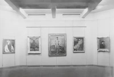 An archival black-and-white installation view of five paintings on a wall. 