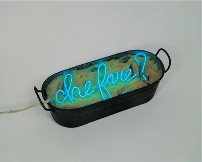 A metal basin with a neon sign reading 