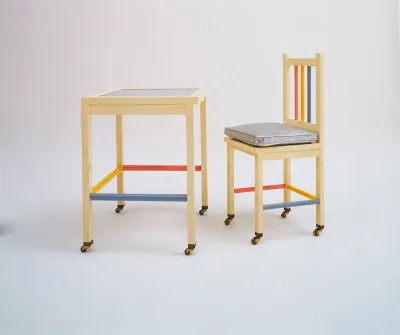 A multicolored table and chair on wheels.