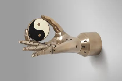 A robotic hand holding a yinyang symbol between its pointer finger and thumb.