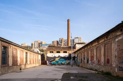 An old building with a large smokestack at its center.