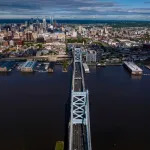 A birds eye view of a bridge leading into a city.