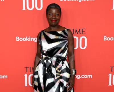 A Black woman in a black and white dress on a red carpet.