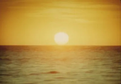 A sun setting over an ocean.