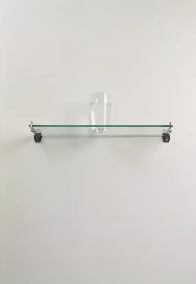 A glass of water on a shelf.