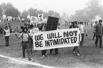 Photograph of students protesting with a large sign that reads 