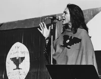 American labor activist and co-founder of the United Farm Workers of America (UFW) Dolores Huerta speaks on stage during a UFW rally, California, 1975 or 1976. She wears a poncho with the UFW logo. (Photo by Cathy Murphy/Getty Images)