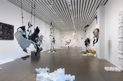 A gallery filled with vine-like sculptures and styrofoam objects.