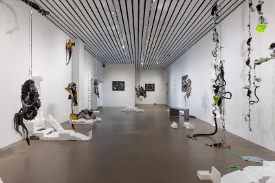 A gallery filled with vine-like sculptures and styrofoam objects.