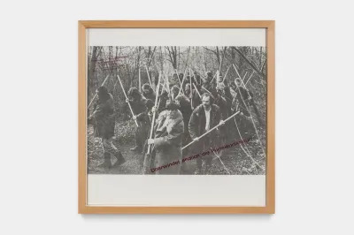 A black-and-white photograph of a group of people in a woods holding shovels.