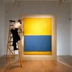 LONDON, ENGLAND - APRIL 10: A gallery technician makes adjustments to the hanging of Mark Rothko