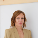 Portrait of a woman standing against a white background.