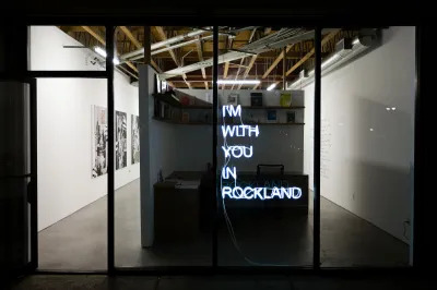 View of a gallery exterior at night showing a neon work that reads 