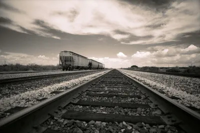 A black-and-white image of a train moving along a track.