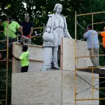 City worker cover the statue of Christopher Columbus at Marconi Plaza, Tuesday, June 16, 2020, in the South Philadelphia neighborhood of Philadelphia. (AP Photo/Matt Slocum)