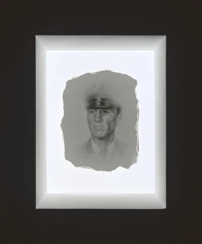 A torn paper showing a drawing of an army portrait of a Latino man.