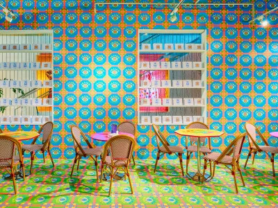 A tea shop with brightly patterned vinyl prints on the floor and ceilings. 