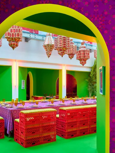 A large table seen through an archway. It is all vibrantly painted and patterned.  