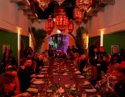 People gather at a long table for a meal. 