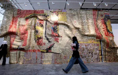 A woman walking past a large curtain-like installation.