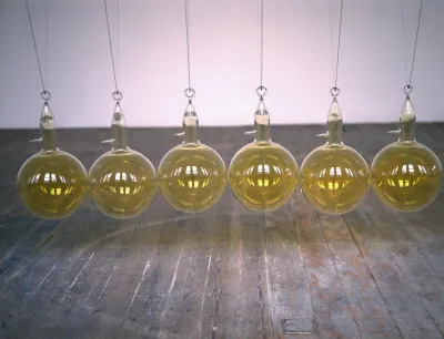 A group of hanging glass balls that are strung up above a floor.