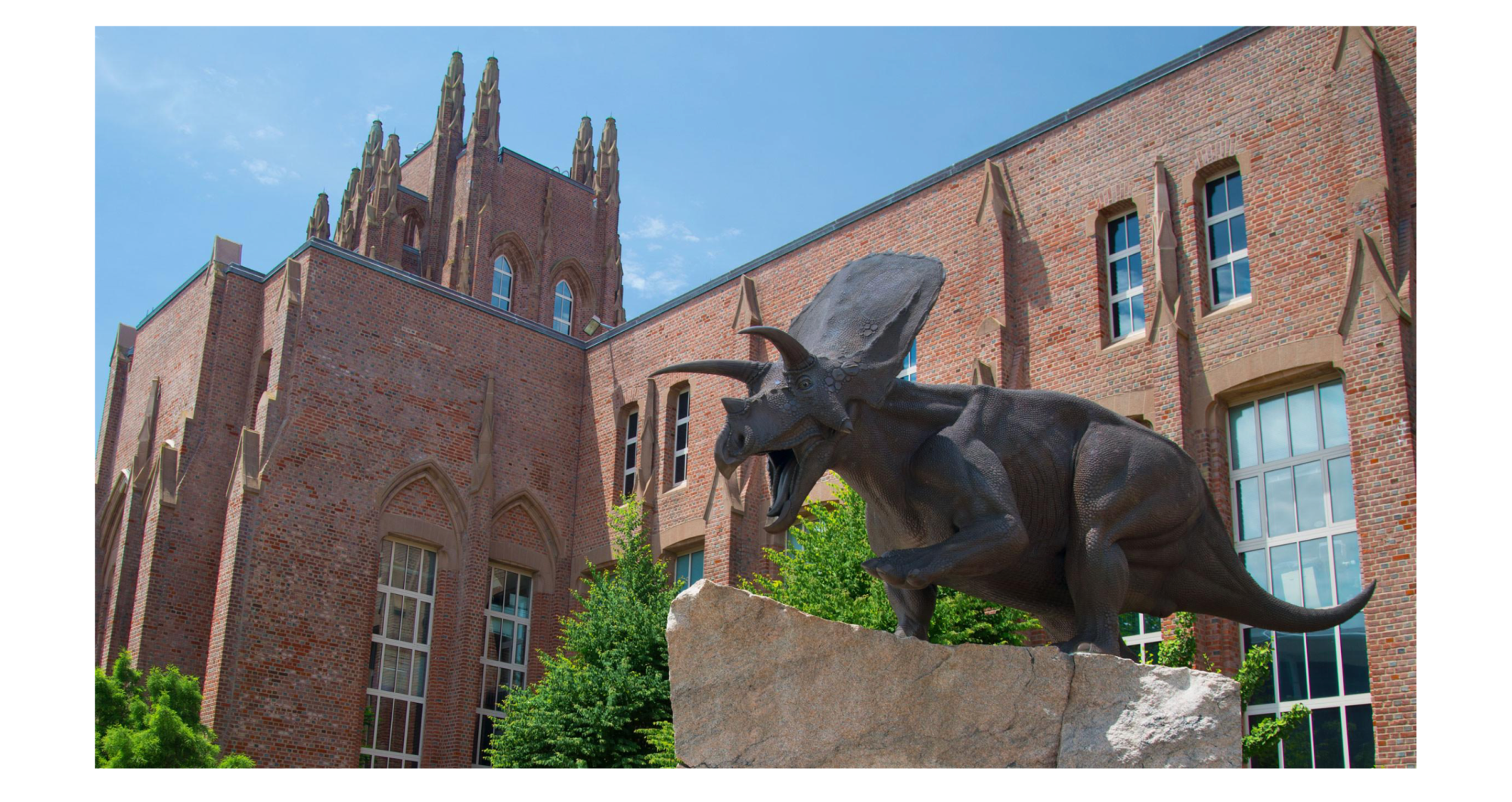 An old building with spires and a dinosaur.