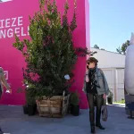 People walk by a bright pink banner labeled Frieze Los Angeles 2022.