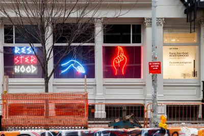 Three neon signs are visible in the exterior windows of a museum. 