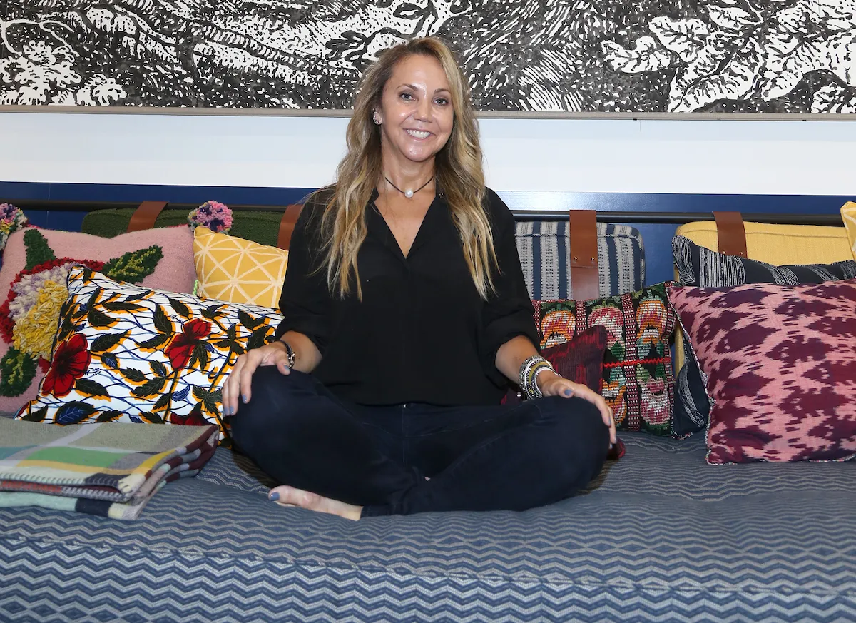 A woman sitting cross-legged on a couch.