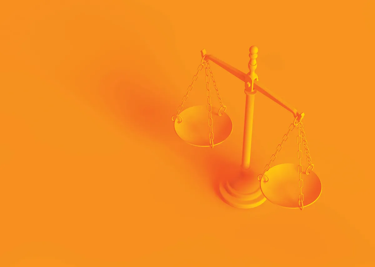 Conceptual image. Scales of justice isolated on orange background.