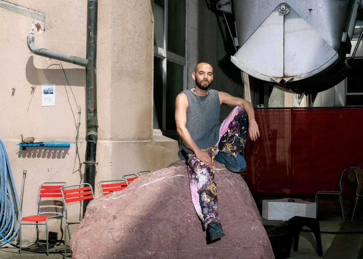 Portrait of Robbie Fitzpatrick, sitting on a giant rock.